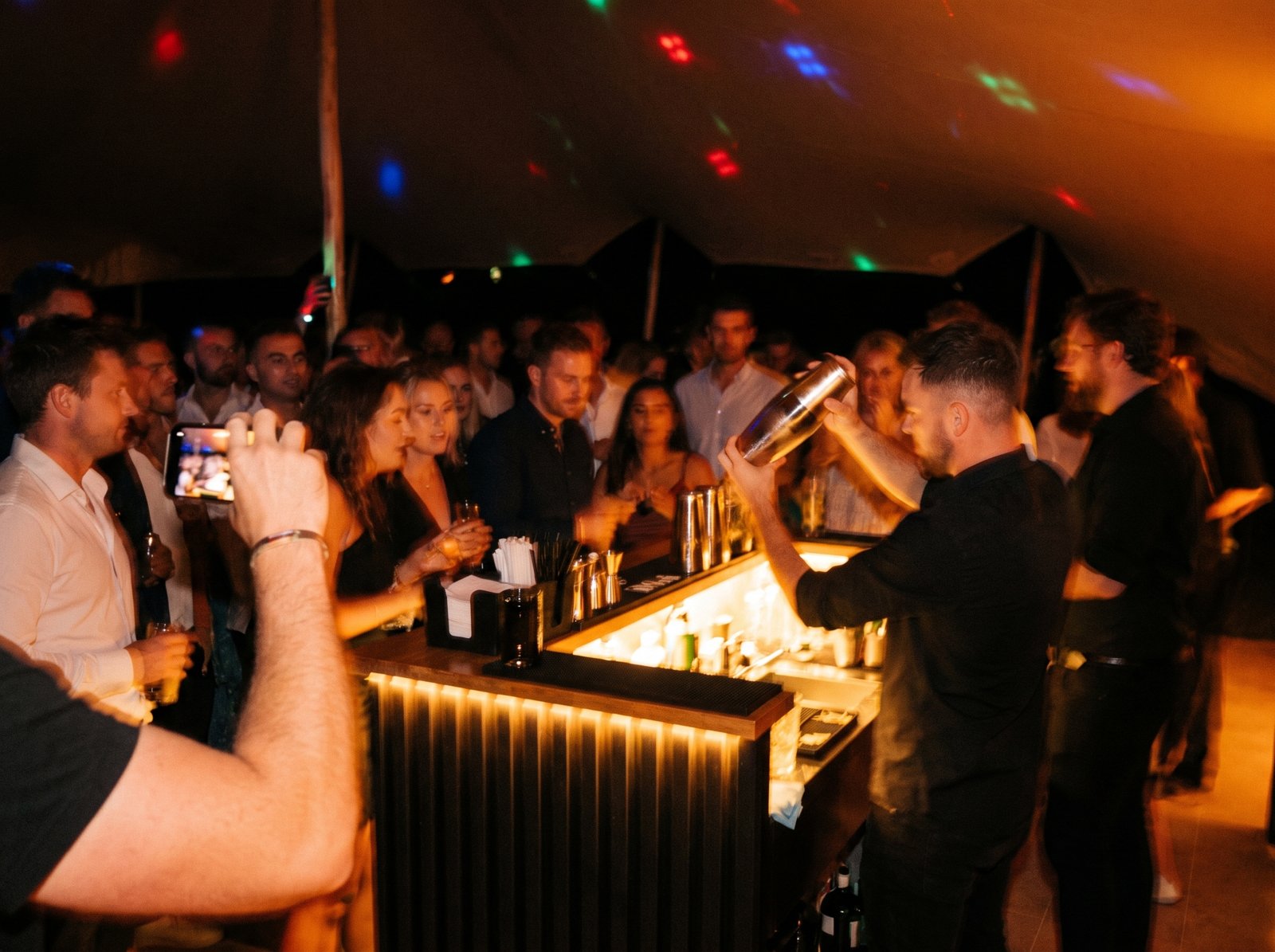 Evening reception crowd at a VIVA bar inside a marquee
