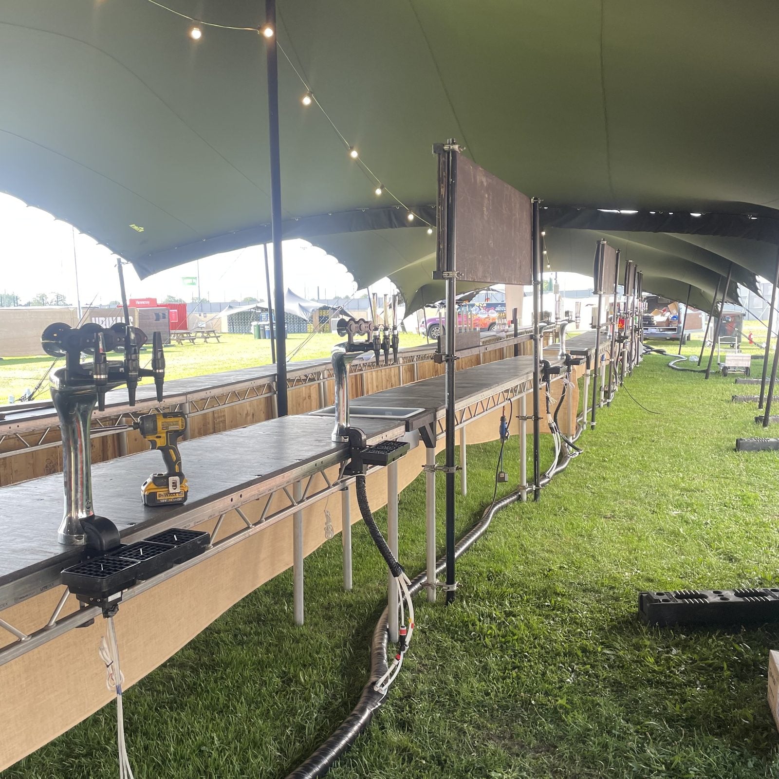 Long-run festival bar under a stretch tent