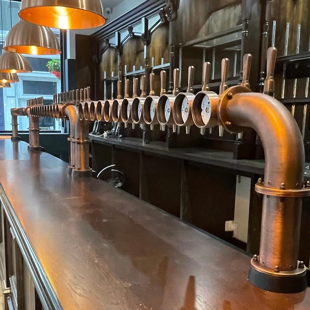 Commercial bar installation — large brass T-bar with multiple taps installed by VIVA