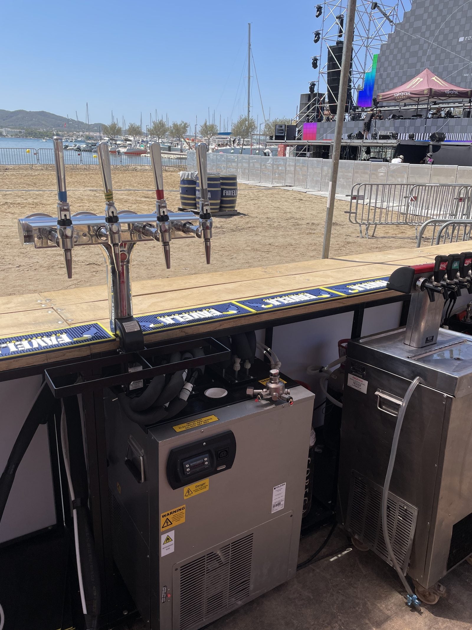 T-bar tap towers mounted on a wooden festival bar build with VIVA cellar equipment underneath at a beach festival in Ibiza