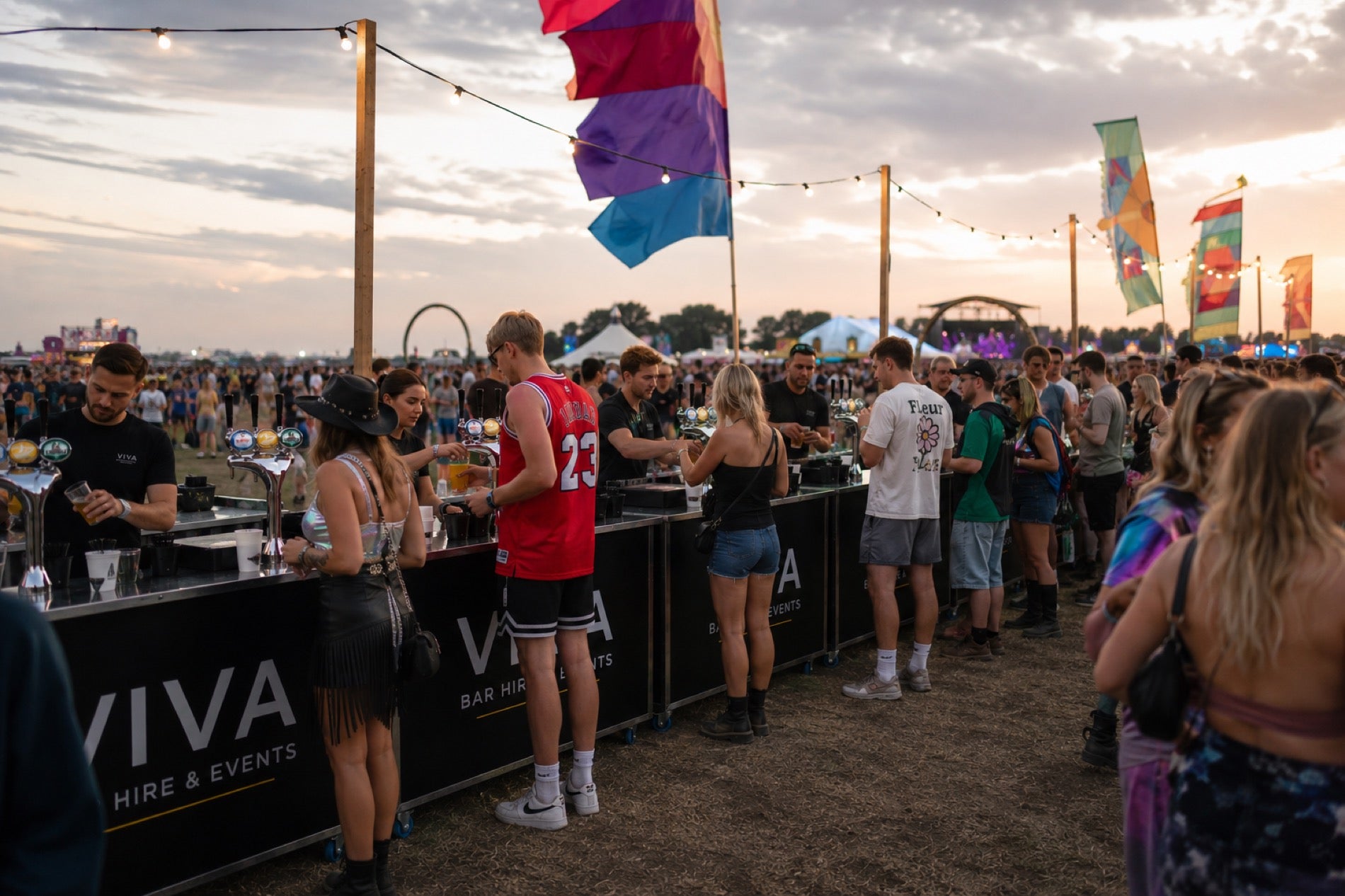 Five VIVA-branded bars in a row at Latitude Festival with queue and stage in background