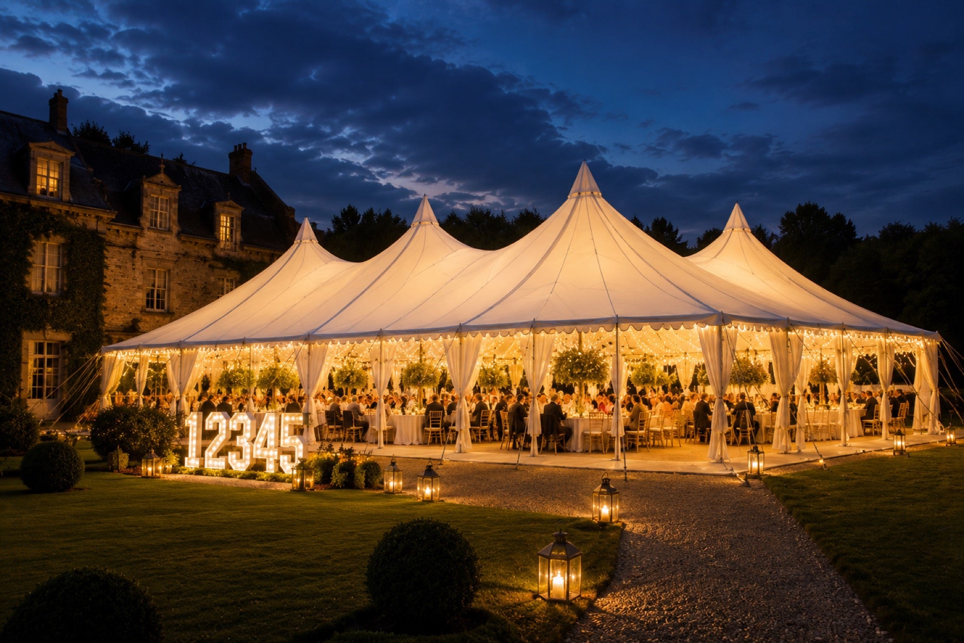 Multi-peaked pavilion marquee at twilight with LED light-up numbers on the lawn