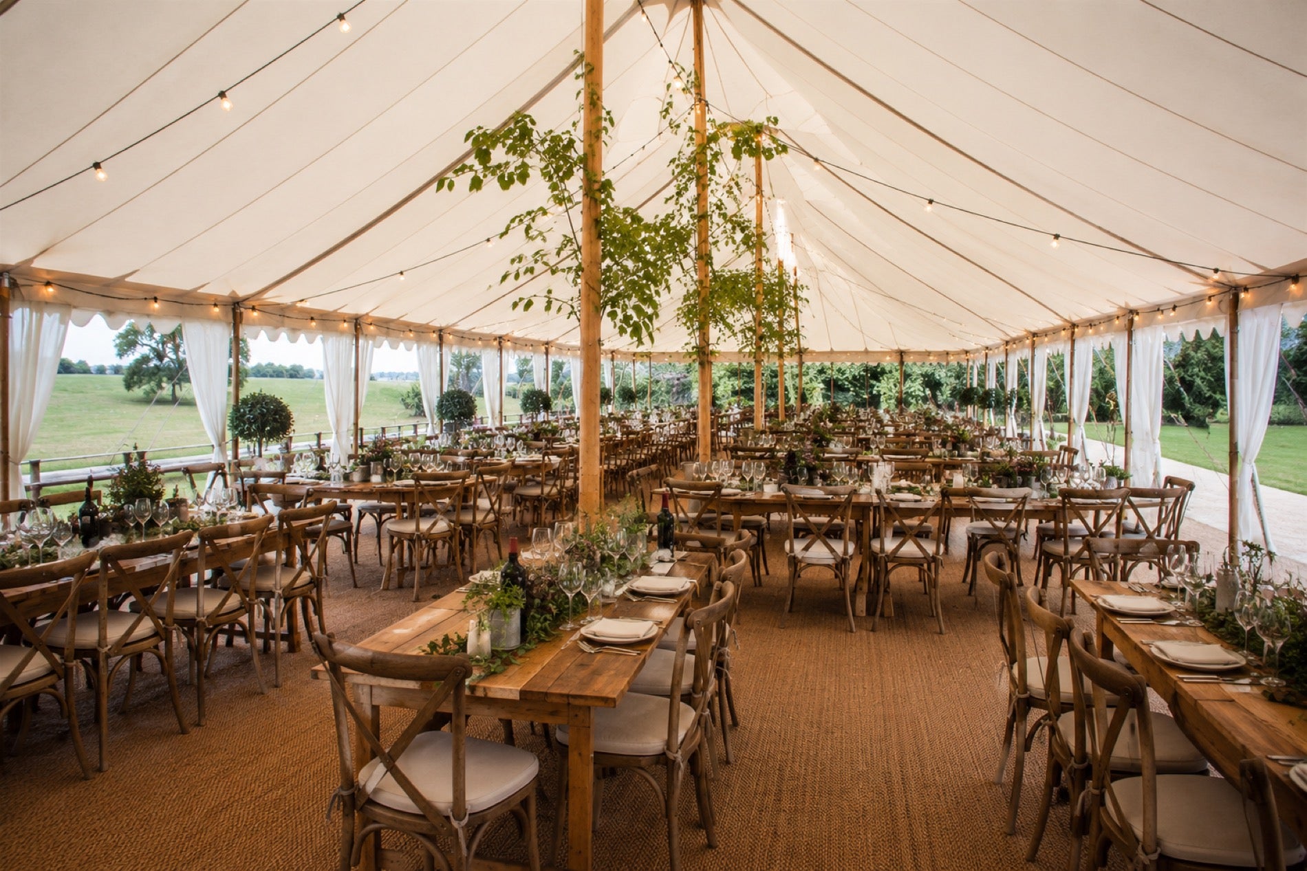 The Sailcloth interior with natural poles, festoon lighting and cross-back chairs