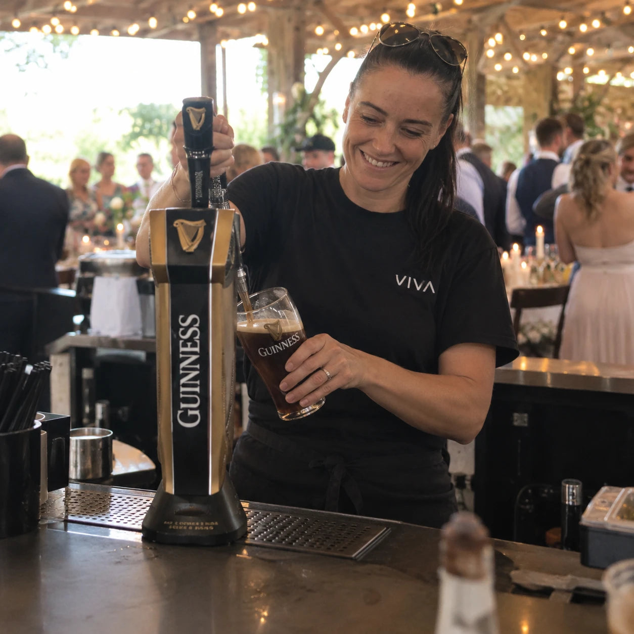 Bartender pouring a pint of Guinness at a wedding bar